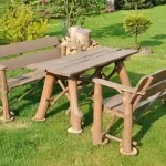 Rustieke houten tuinmeubelset met een tafel en twee banken op een groen gazon
